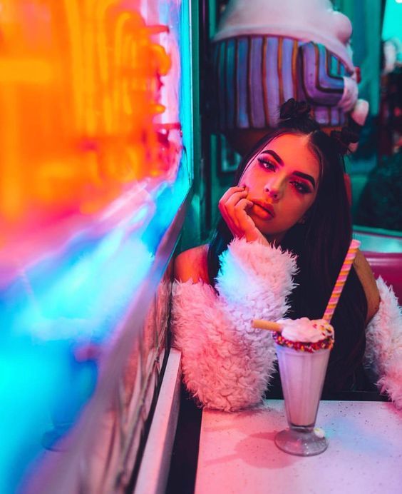 a woman sitting at a table with a drink