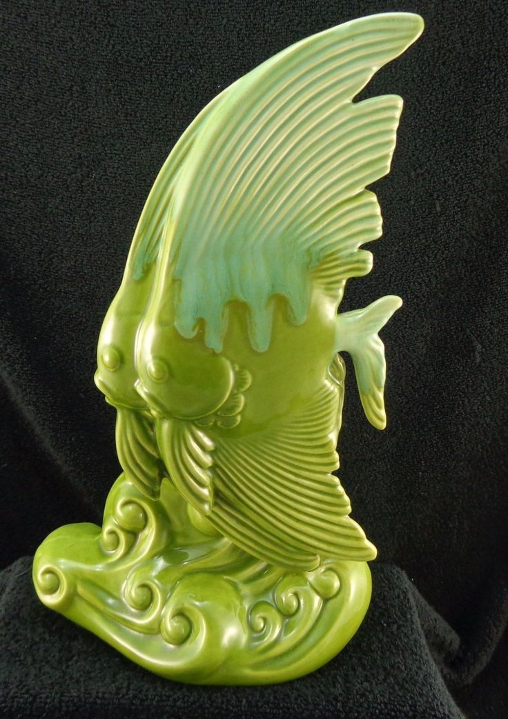 a green glass figurine sitting on top of a black cloth