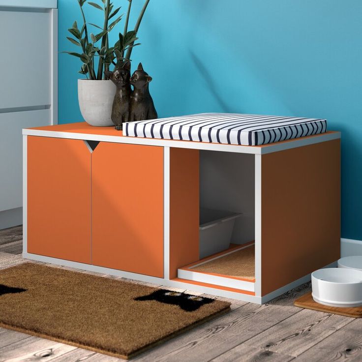 an orange and white sideboard in a blue room with a potted plant next to it