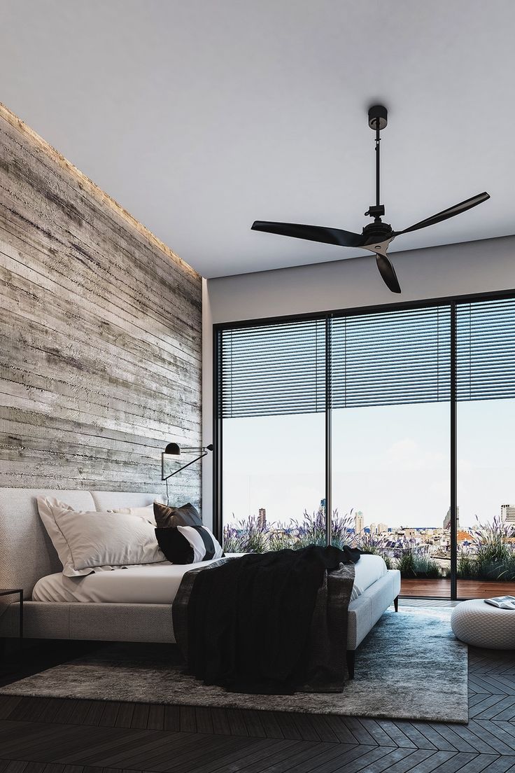 a living room with large windows and a ceiling fan