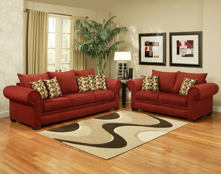 a living room filled with red couches and chairs on top of a hard wood floor