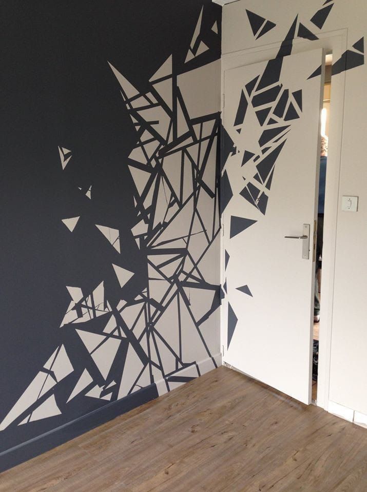 the wall is painted with black and white geometric designs on it's walls, along with wooden flooring