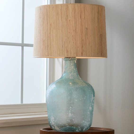 a blue vase sitting on top of a table next to a lamp