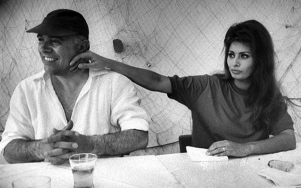 a man sitting next to a woman at a table in front of a white wall