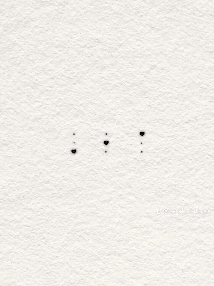 three black dots on white paper with one small dot in the middle and two smaller dots at the bottom