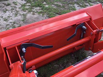 the front end of a red truck with its door open and seat folded down on grass