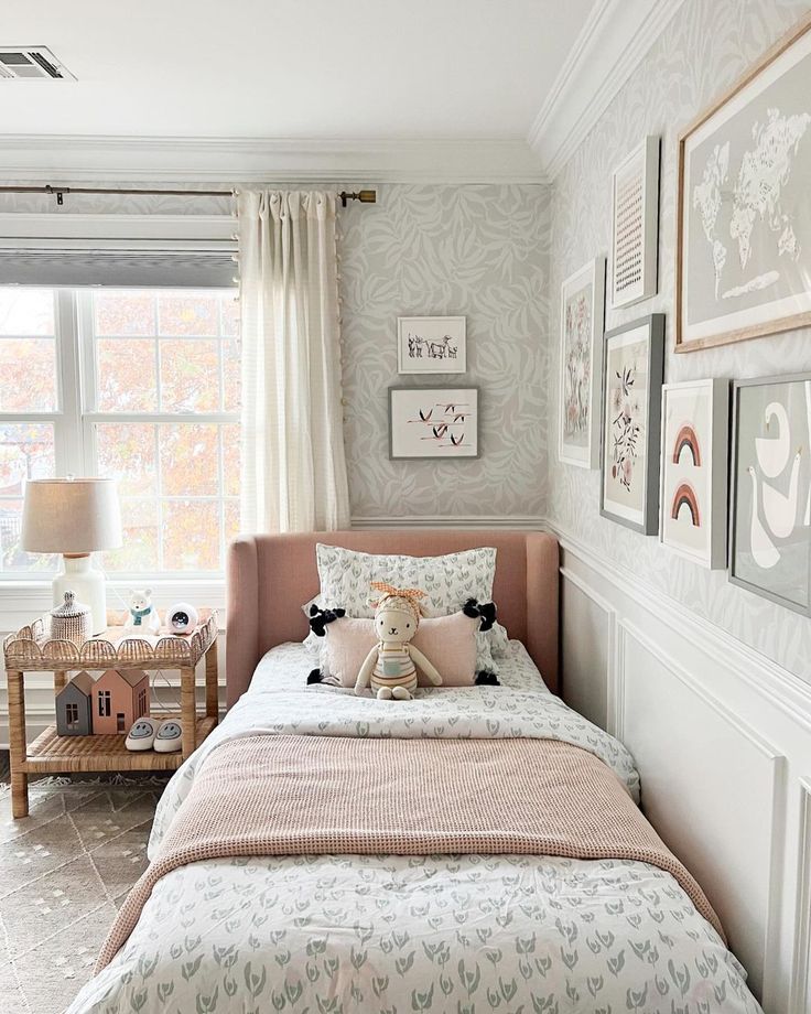 a bedroom with a bed, window and pictures on the wall above it's headboard