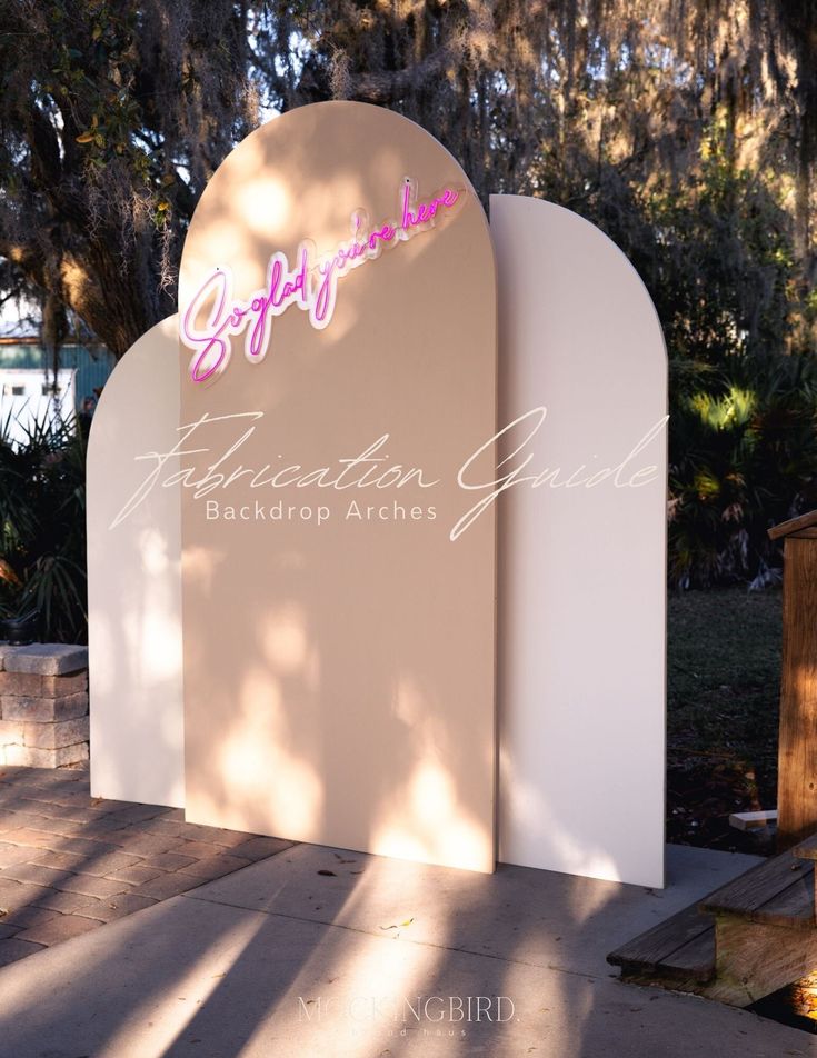 the entrance to an event venue with pink and white letters that read celebration guide back drop arches