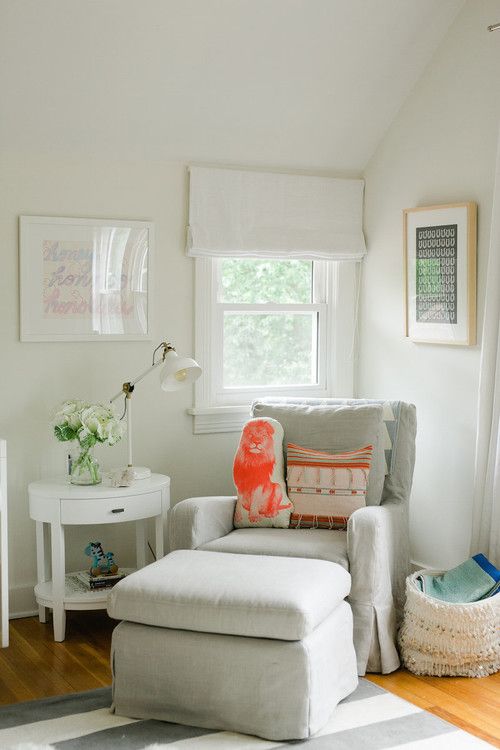 a living room filled with furniture and a white rug on top of a hard wood floor