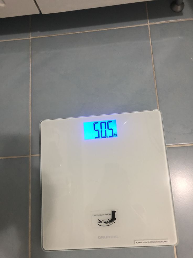 a bathroom scale with the time displayed on it's display screen in front of a tiled floor