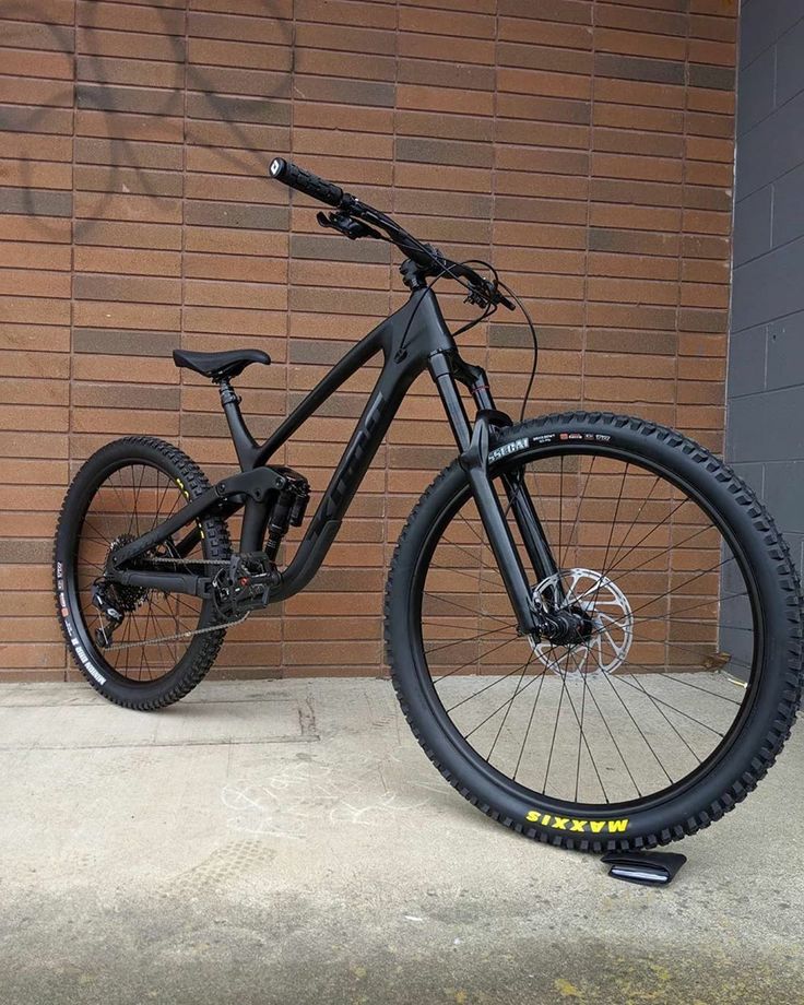 a mountain bike parked in front of a brick wall