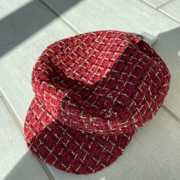 a red hat sitting on top of a white tile floor