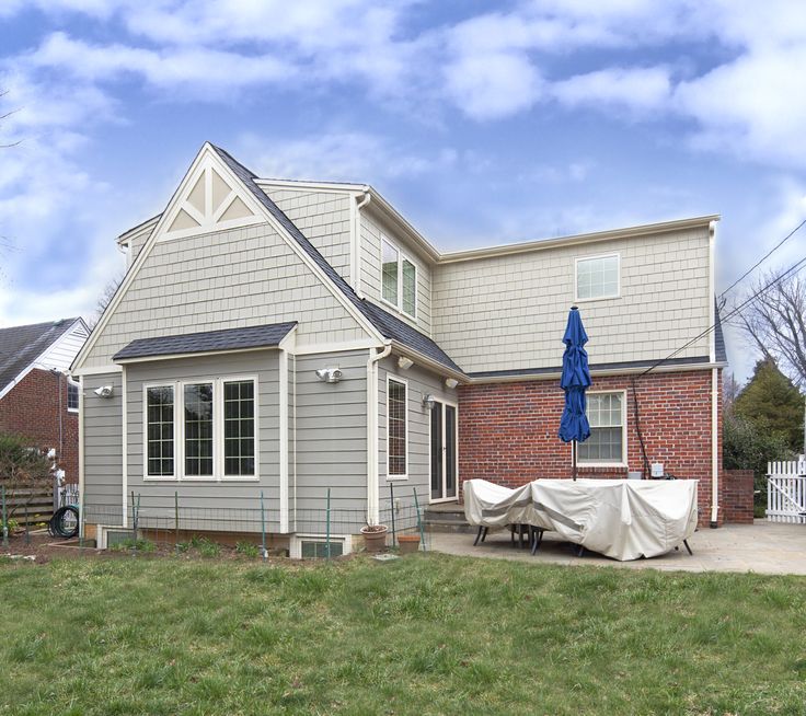 a house with a covered patio in front of it and an umbrella on the back