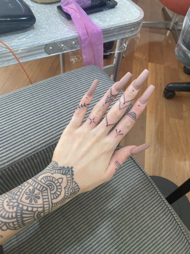 a woman's hand with tattoos on it