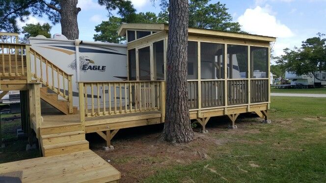 a mobile home with stairs leading to the porch and second story deck in front of it