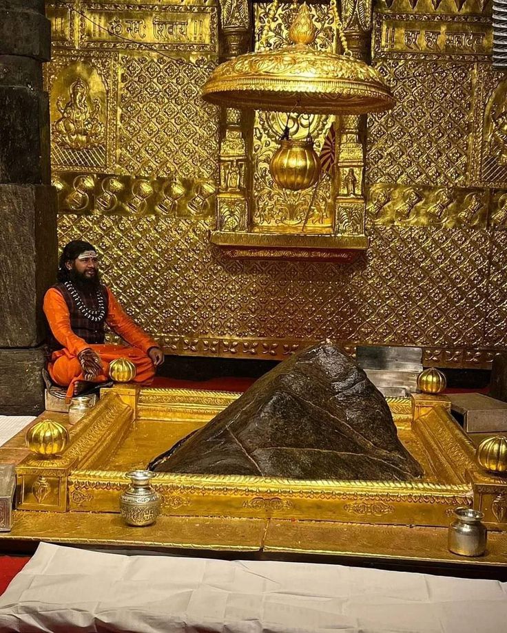 a man sitting in front of a golden altar