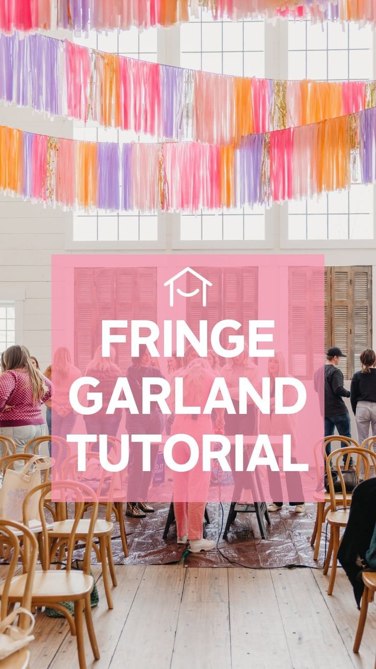 people sitting at tables with fringe garlands hanging from the ceiling in front of them