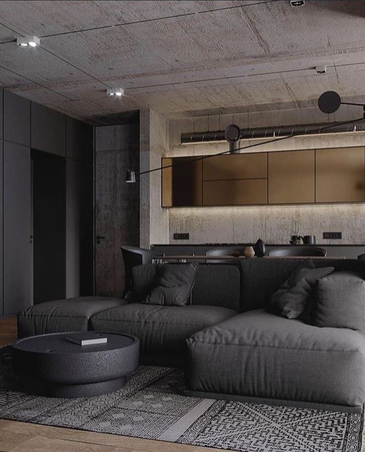 a large gray couch sitting on top of a wooden floor next to a living room filled with furniture