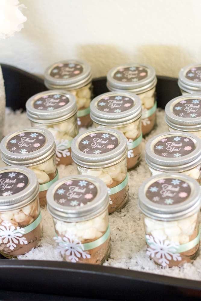 there are many jars with cookies in them on the tray and snowflakes all around