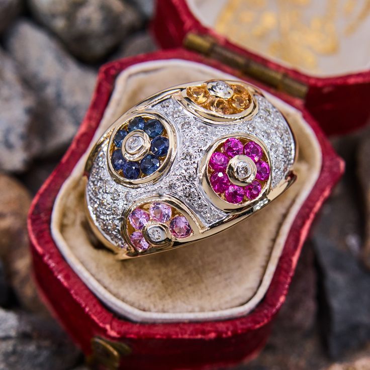 This glorious Levian dome ring is accented with twenty-two channel set sapphires or rubies in pink, yellow, blue, and red hues. The ring is further decorated with sparkling round brilliant cut diamond accents. It is crafted of 14k yellow gold and is currently a size 7. Multicolor Brilliant Cut Round Sapphire Ring, Multicolor Brilliant Cut Diamond Ring, Round Multi-stone Diamond Sapphire Ring, Multicolor Brilliant Cut Sapphire Diamond Ring, Multi-stone Sapphire Ring With Diamonds, Multicolor Oval Sapphire Ring With Diamonds, Multicolor Sapphire Ring, Multicolor Round Sapphire Ring Fine Jewelry, Multicolor Sapphire Ring Fine Jewelry