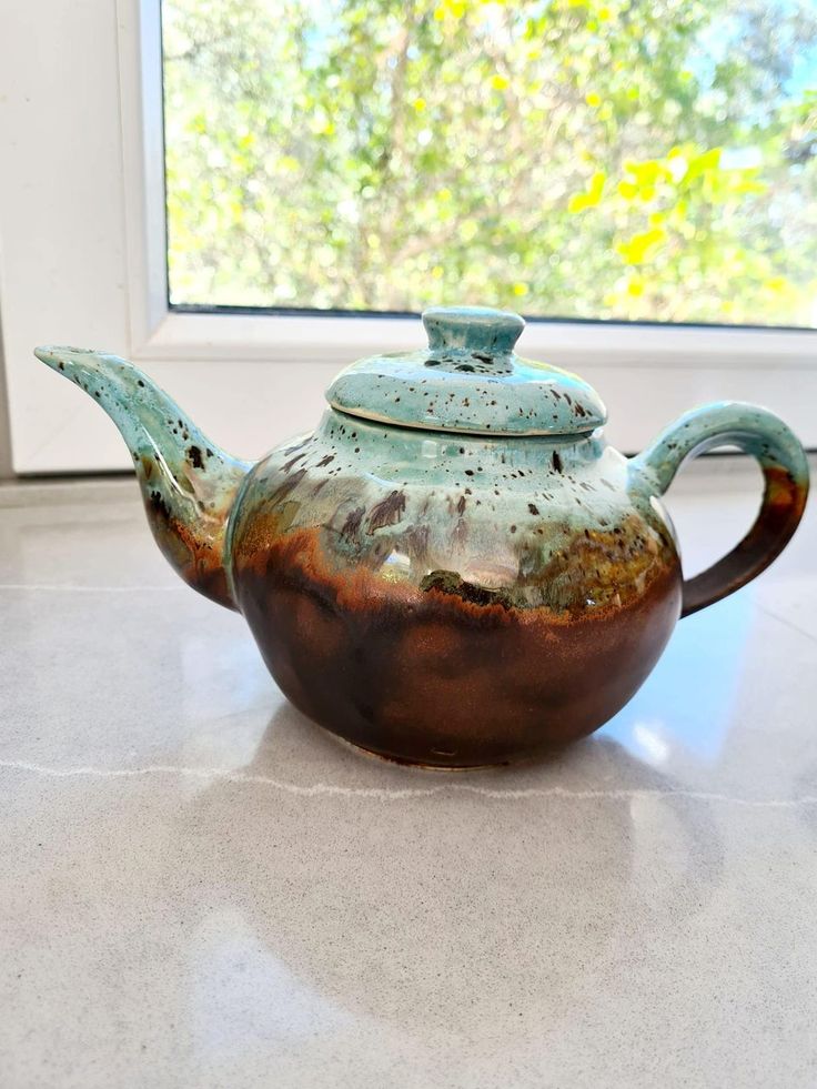 a teapot sitting on top of a counter next to a window with the words,'first post here this is black walnut over genote