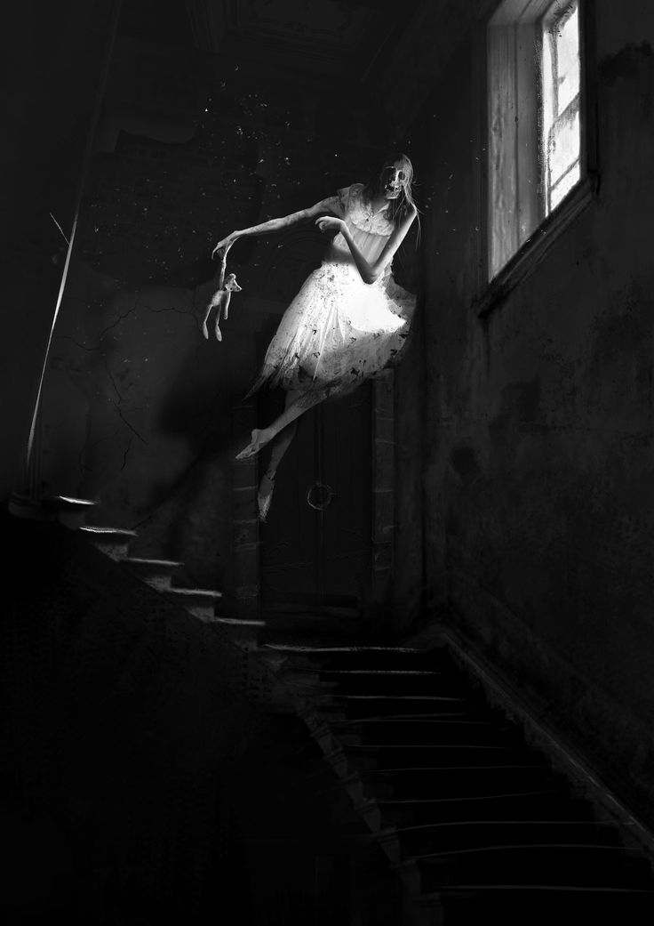 a woman is walking down the stairs in a dark room with light coming from her window