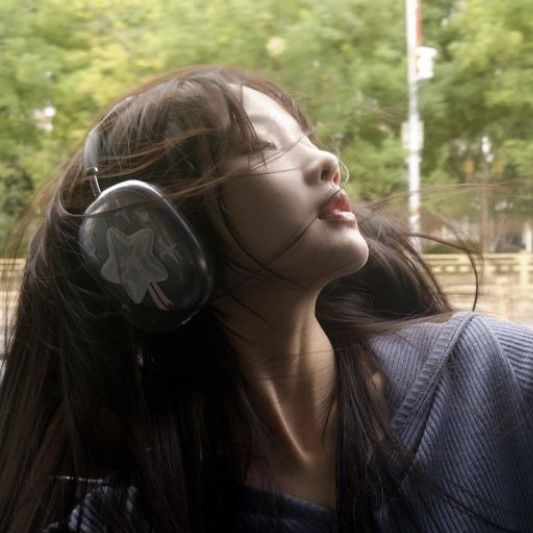 a woman wearing headphones looking out the window