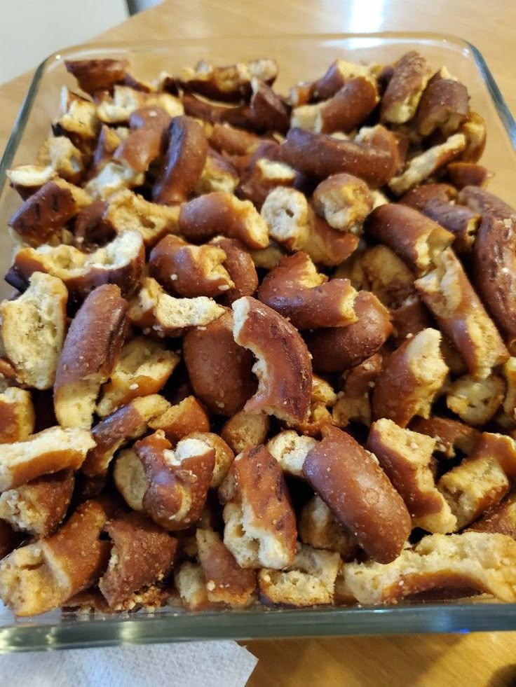 a glass dish filled with nuts on top of a wooden table