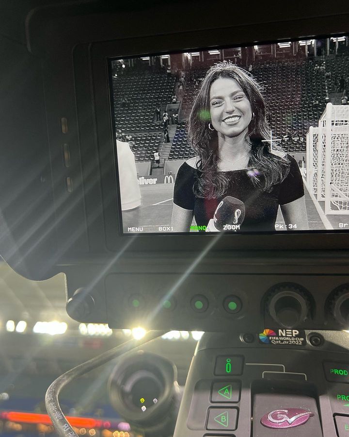 a woman is shown on the screen of a vehicle's dash camera while it sits in front of an empty stadium