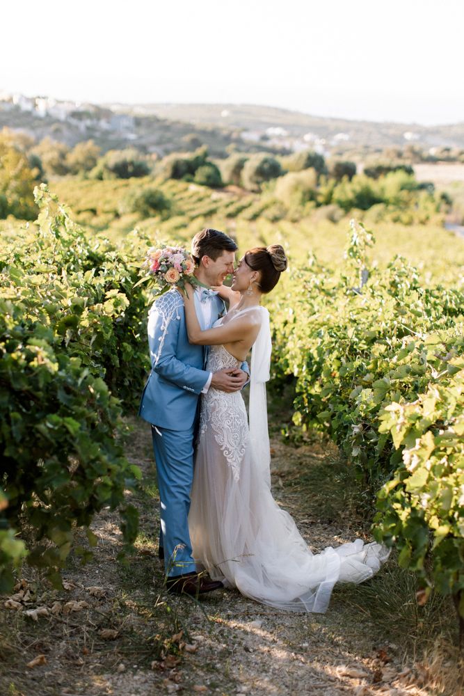 a bride and groom kissing in the vineyard