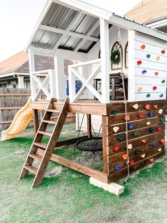 a child's play house made out of pallet boards and wooden ladders