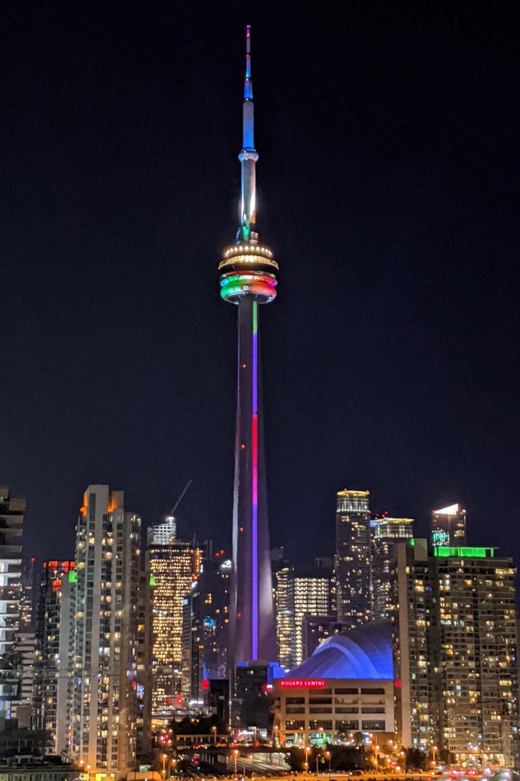 the city skyline is lit up at night with bright lights and skyscrapers in the background