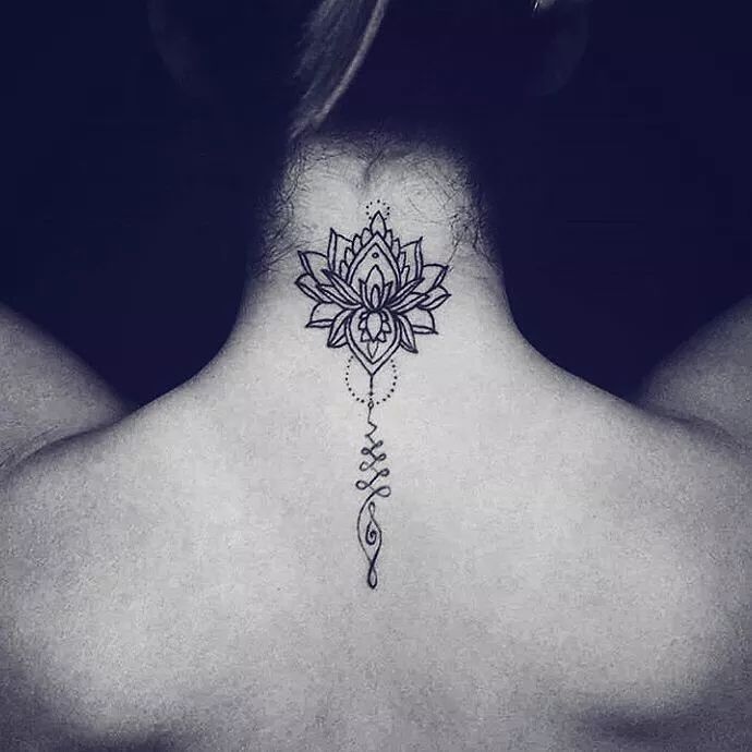 the back of a woman's neck with a lotus tattoo on it