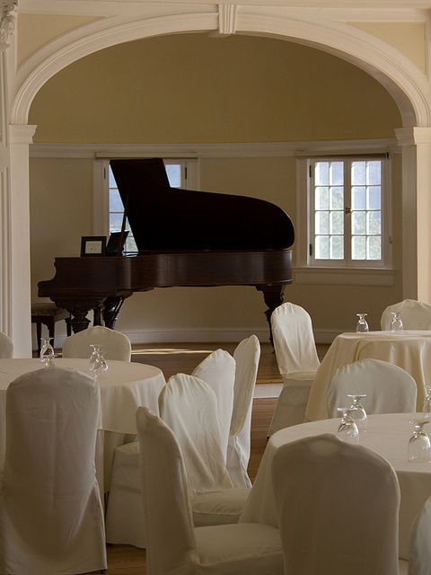 a grand piano is in the middle of a room with tables and chairs set up for formal function