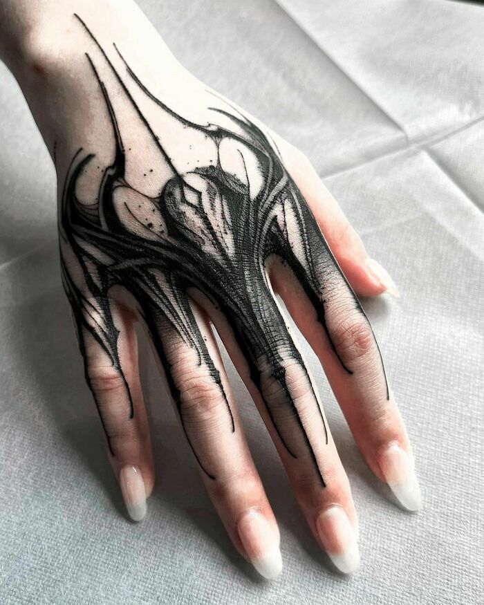 a person's hand with black ink on it and an intricate design in the middle