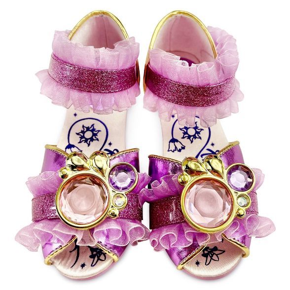 a pair of pink shoes with bows and jewels on the toes, all decorated in gold