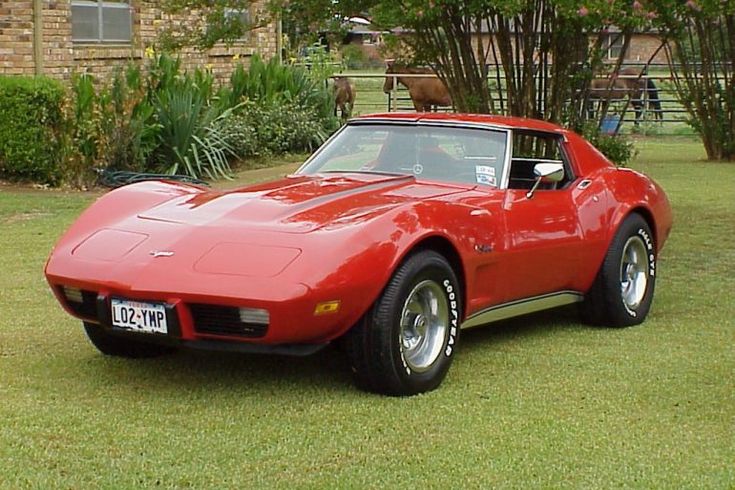 a red sports car is parked in the grass