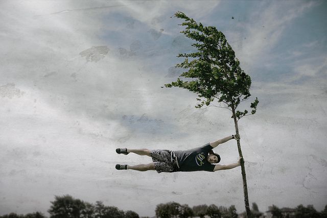 a man is in the air near a tree