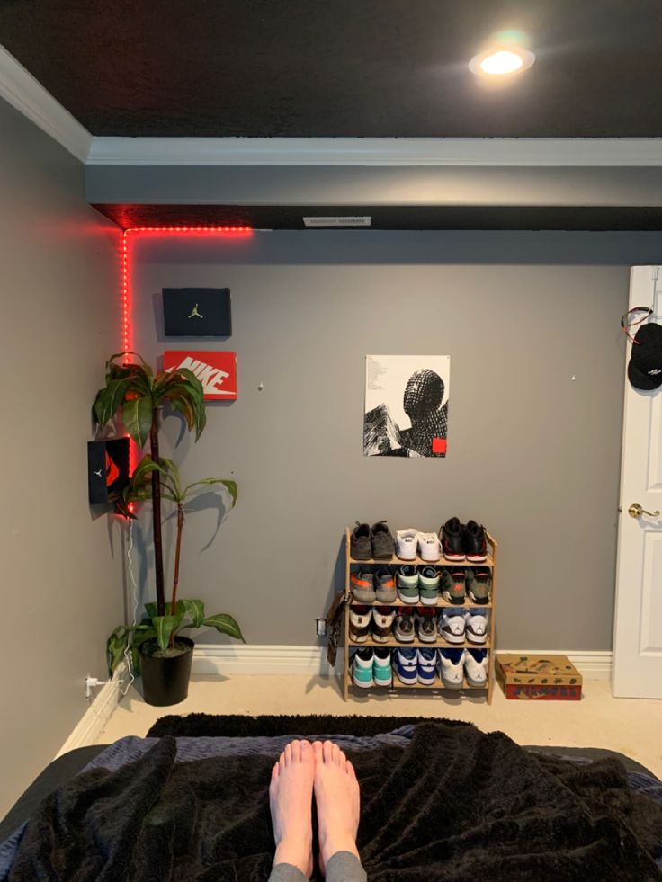 a person laying on a bed with their feet propped up in front of a shoe rack