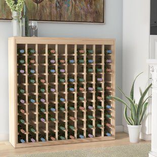 a wooden wine rack filled with lots of bottles next to a painting on the wall