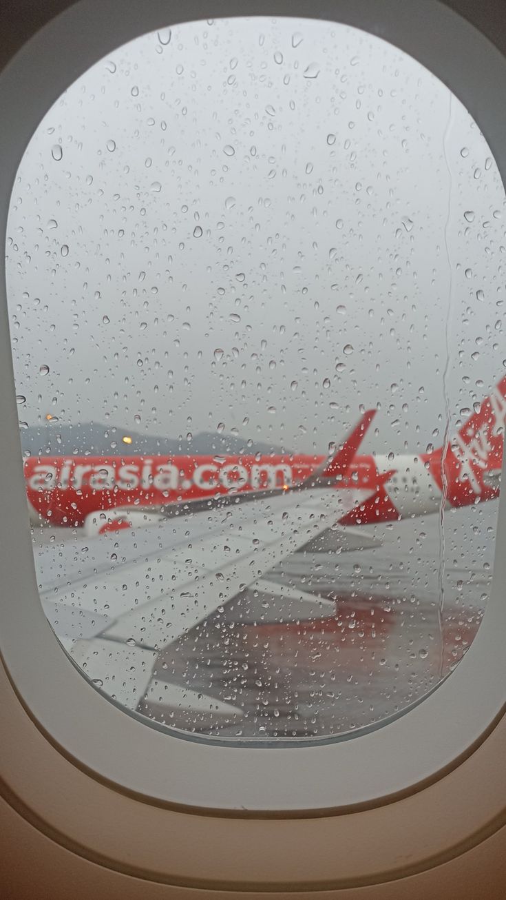 an airplane window with rain drops on it