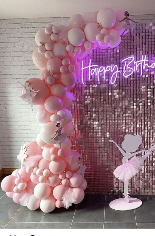 a birthday cake made out of balloons with a ballerina figure on the side and a pink backdrop behind it