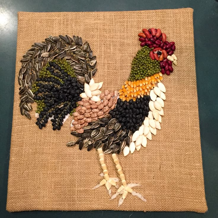 a close up of a rooster on a piece of burlied fabric with flowers