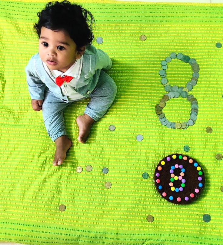 a baby laying on top of a green blanket