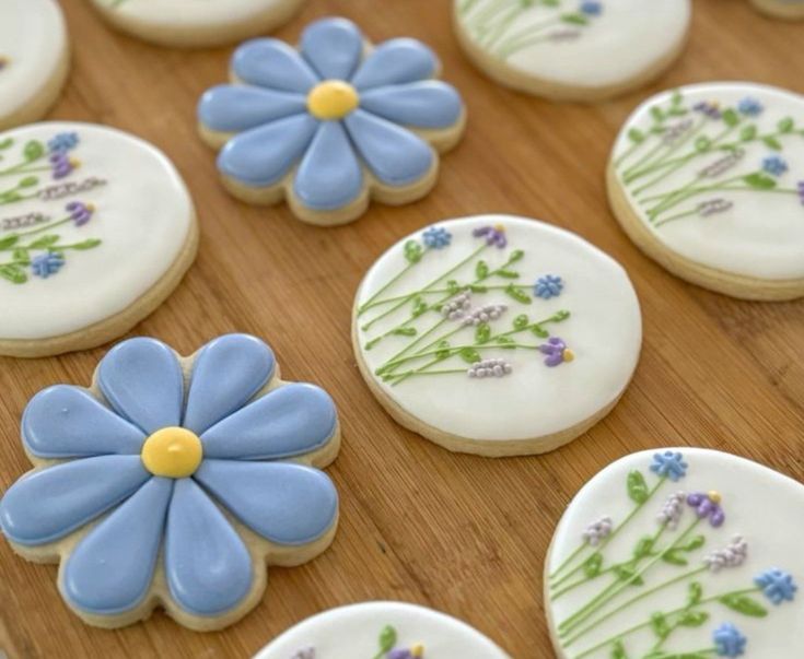 decorated cookies with blue and yellow flowers on a wooden table