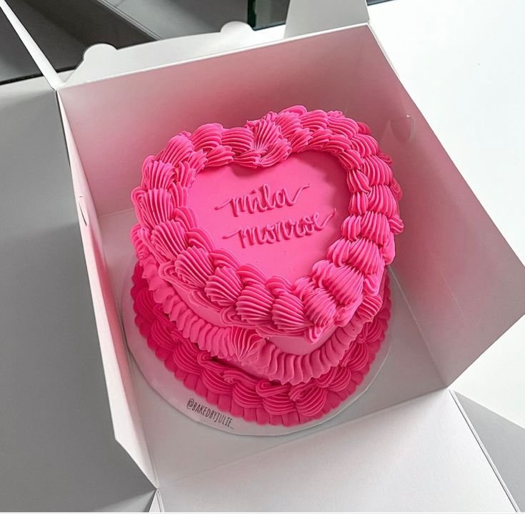 a pink heart shaped cake in a box