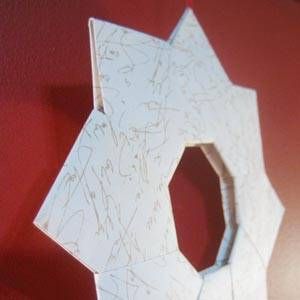 a white paper sculpture on a red wall