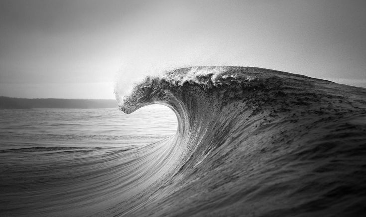 a large wave in the ocean on a cloudy day