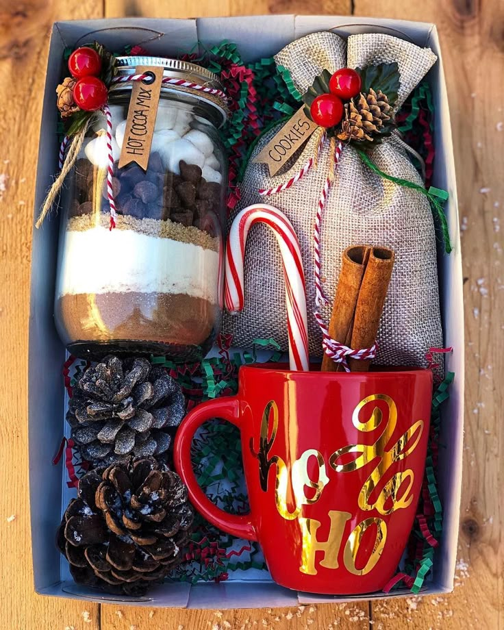 a christmas gift box with hot chocolate, candy canes and cookies in the mug