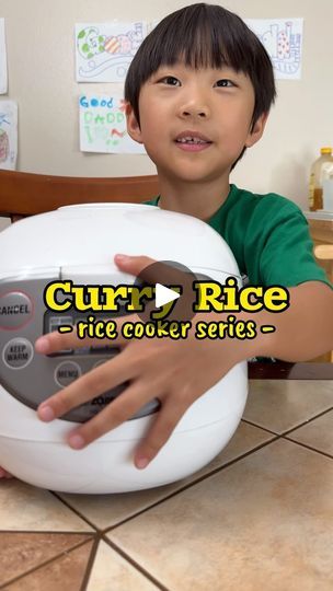 a young boy is holding a rice cooker